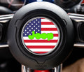 Round American flag center-cap decal with lime-green Jeep wordmark on a Wrangler steering wheel airbag cover