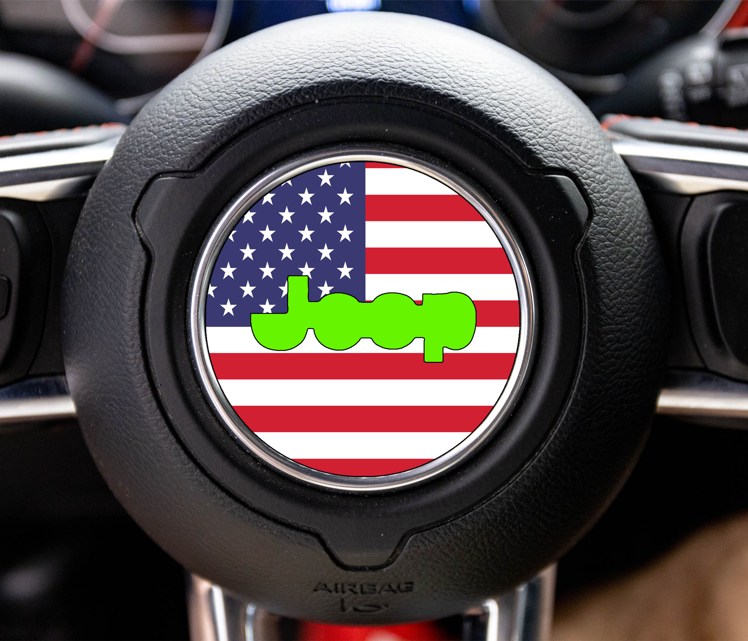 Round American flag center-cap decal with lime-green Jeep wordmark on a Wrangler steering wheel airbag cover